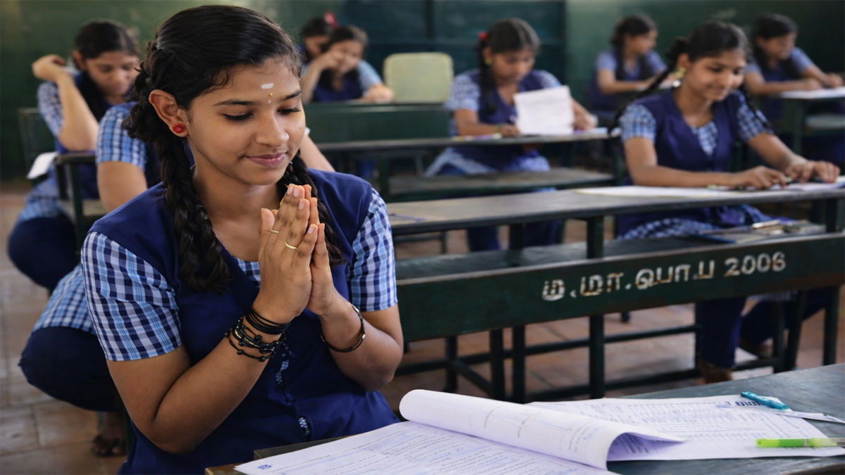 Tamil Nadu 12th public exam student praying before writing exam in classroom with result expectation