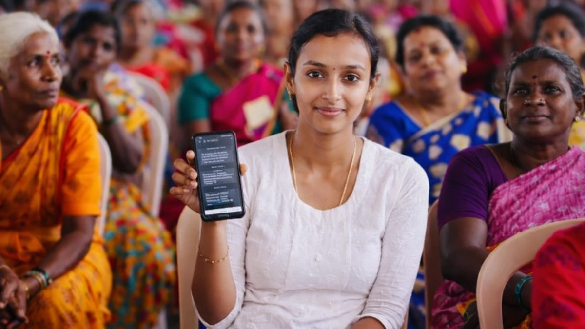 தமிழக பெண்கள் மகளிர் உரிமைத் தொகை திட்டம் தொடர்பான தகவலை மொபைலில் பார்க்கும் காட்சி
